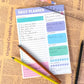 Daily planner notebook page with colorful blocks, lined checklist fields, and notes