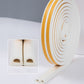 White foam sealing strip with yellow border tape, rolled and ready for door gaps