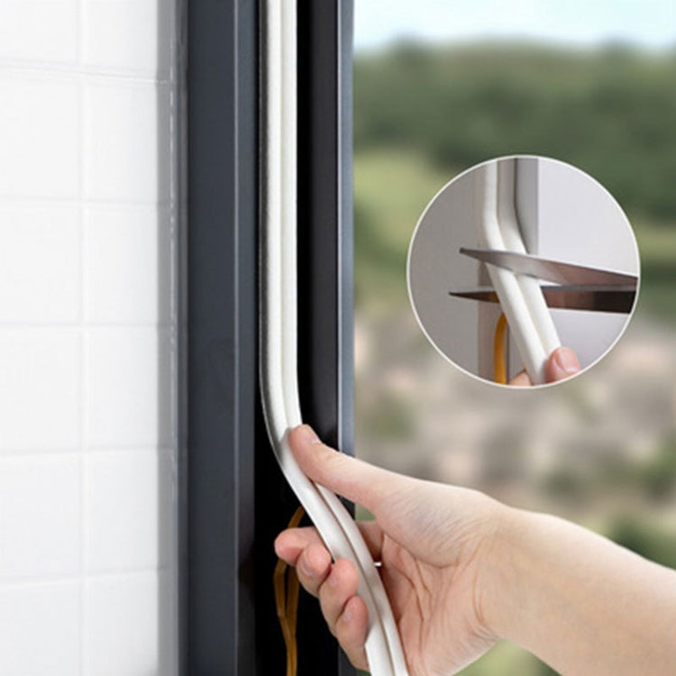 White foam sealing strip being pressed along a door frame edge for draft blocking