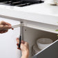 White foam sealing strip applied along cabinet or door edge to seal gaps around hinges