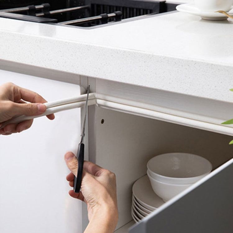White foam sealing strip applied along cabinet or door edge to seal gaps around hinges