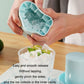 Blue silicone ice cube cup mold being removed by hands, with ice inside