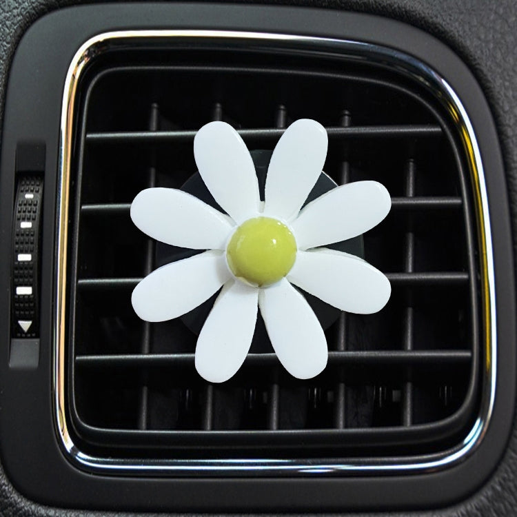 White daisy air vent aromatherapy clip with light yellow-green center, on car vent
