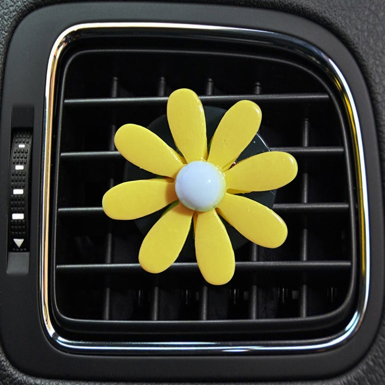 Yellow daisy air vent aromatherapy clip with light blue center, clipped to car vent