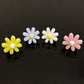 Set of four daisy air vent clips in yellow, light blue, white, and pink