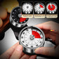 Stainless steel mechanical kitchen timer with red dial markings, held in hands