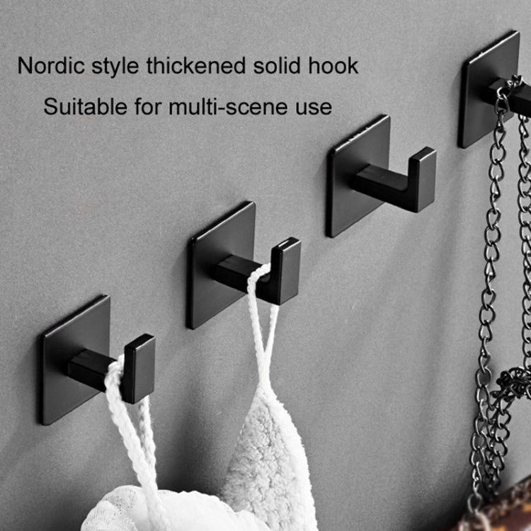 Black wall coat hook holding a white towel or rope for hanging storage