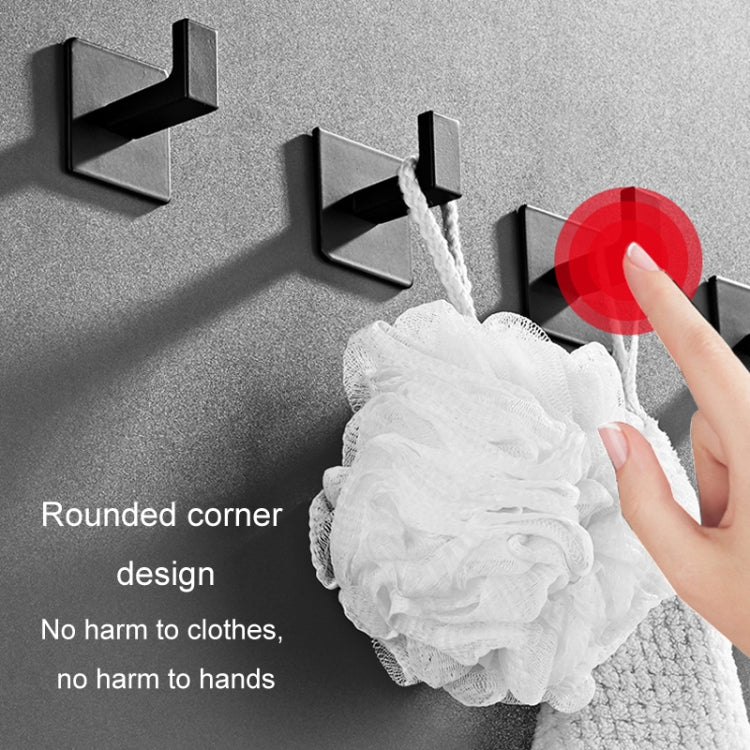 Black wall hook with rounded open profile holding a white cleaning cloth