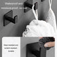 Multiple black wall hooks holding a white towel with hanging loops