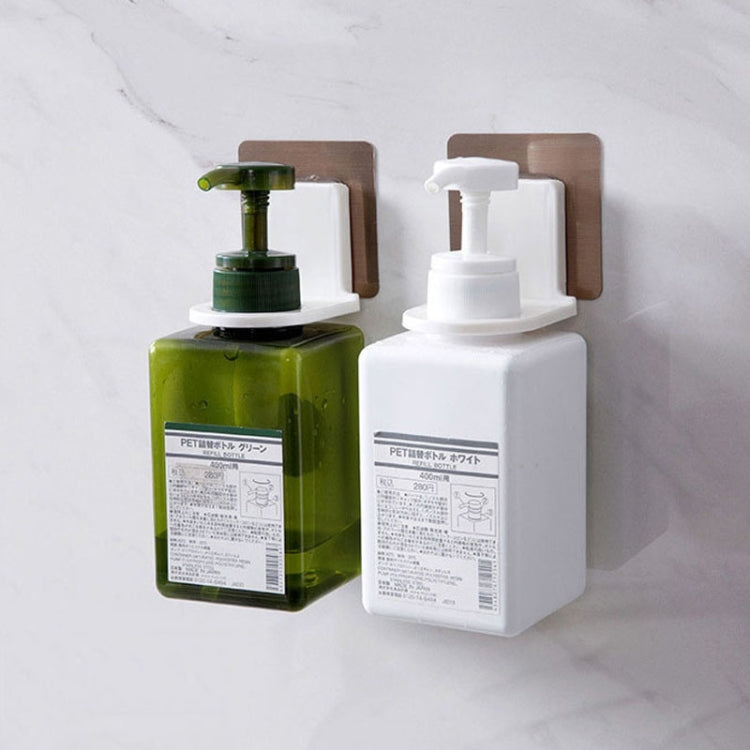 Wall-mounted soap dispenser holders for bottles, white and green pump bottles shown