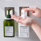 Hand inserting soap dispenser pump into a white wall-mounted holder