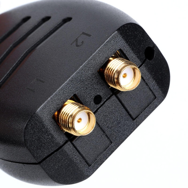 Close-up of black connector panel with two gold RF sockets and mounting holes