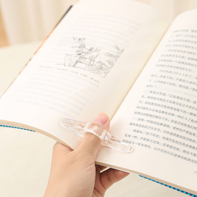 Hand using a transparent acrylic thumb bookmark to hold an open book page.