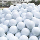 Pile of white floating golf practice balls, dimpled surface