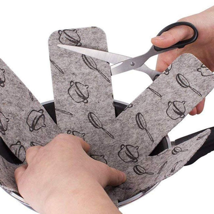 Gray felt pot bottom pads with kettle icon pattern being fitted around a skillet