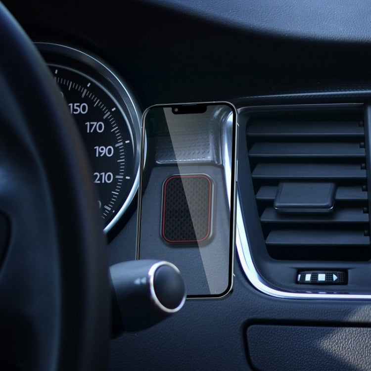 Magnetic phone holder mounted on car dashboard with flat adhesive backing and vent near