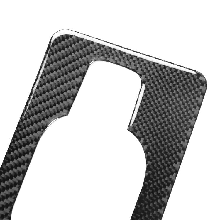 Close-up of black carbon-fiber trunk handle sticker with oval cutout panel