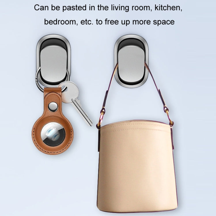 Two silver oval adhesive car hooks with black bases, mounted with hanging items