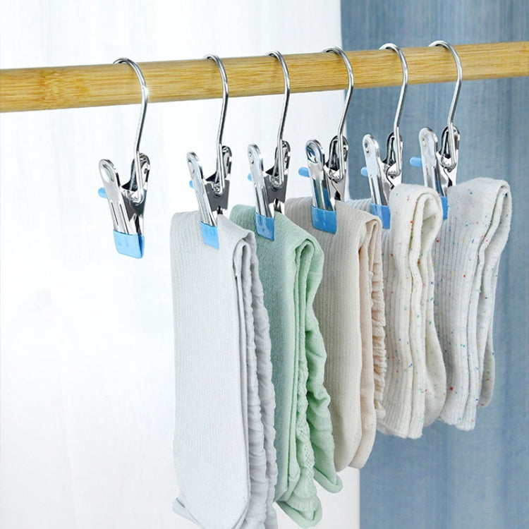 Laundry drying clips holding folded socks on a wooden bar, blue anti-scratch tabs