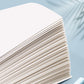 Thick stack of blank notebook pages with tightly layered, even paper edges