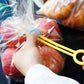 Yellow sealing tape clip held by hand on a plastic food bag