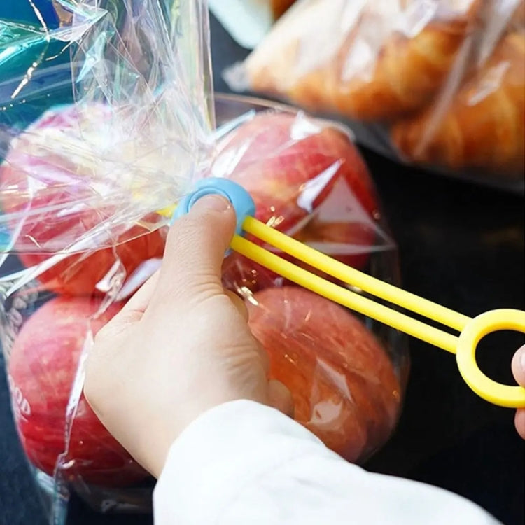 Yellow sealing tape clip held by hand on a plastic food bag