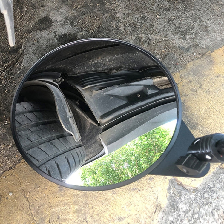Handheld round inspection mirror showing reflected vehicle wheels
