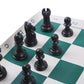 Foldable portable chess set close-up of black chess pieces on green-and-white squares