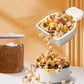White drying scoop pouring brown granules into a white storage bin