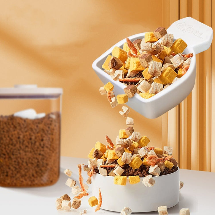 White drying scoop pouring brown granules into a white storage bin