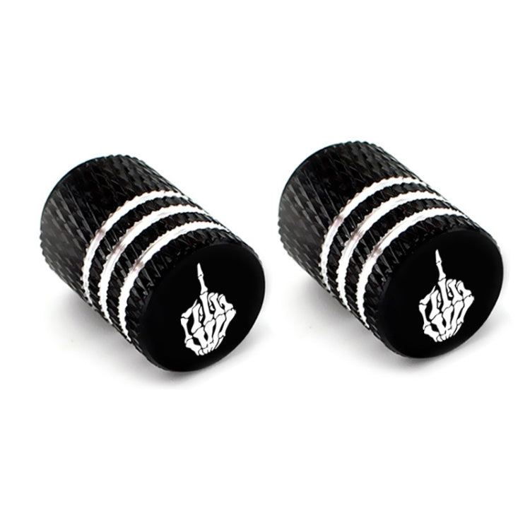 Pair of black tire valve stem caps with silver stripes and white skull emblems