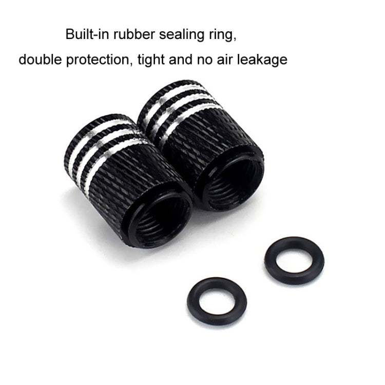 Pair of black tire valve caps with white skulls plus rubber sealing rings