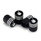 Black tire valve caps with silver stripes and white skull emblems, angled view