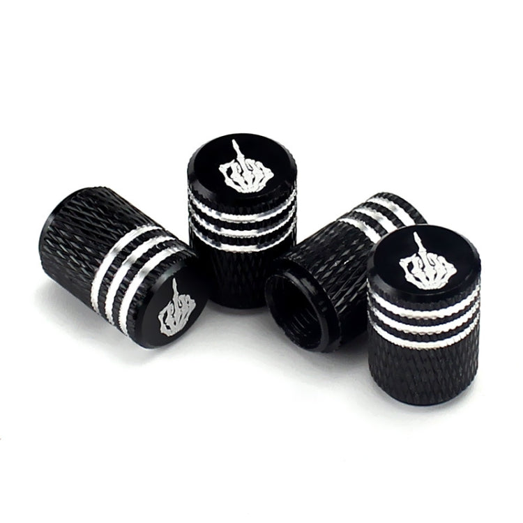 Black tire valve caps with silver stripes and white skull emblems, angled view