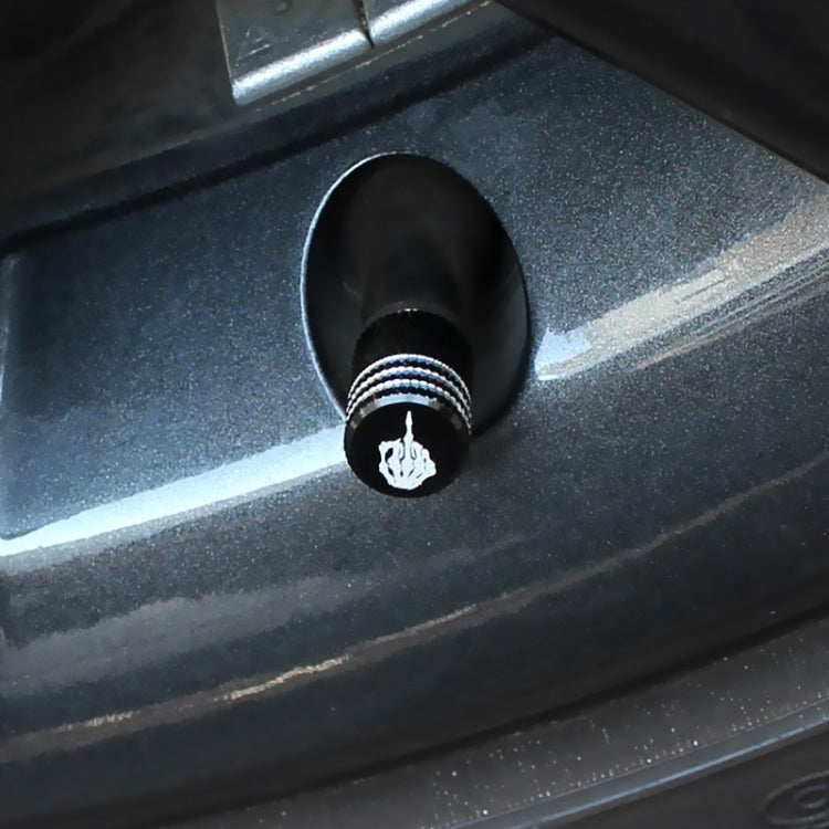 Installed black tire valve cap with silver-striped band and white skull emblem