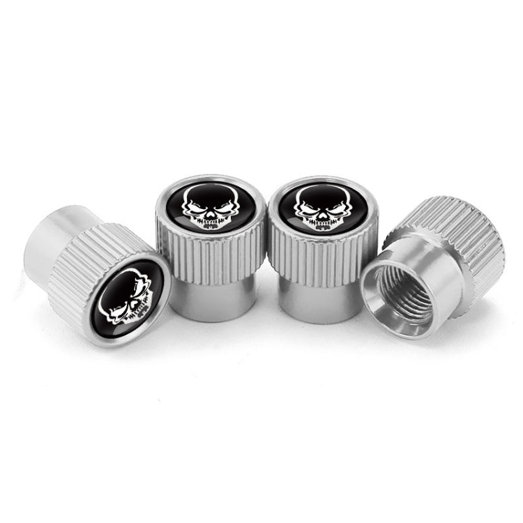 Set of 4 silver valve caps with black skull emblem, one shows threaded opening