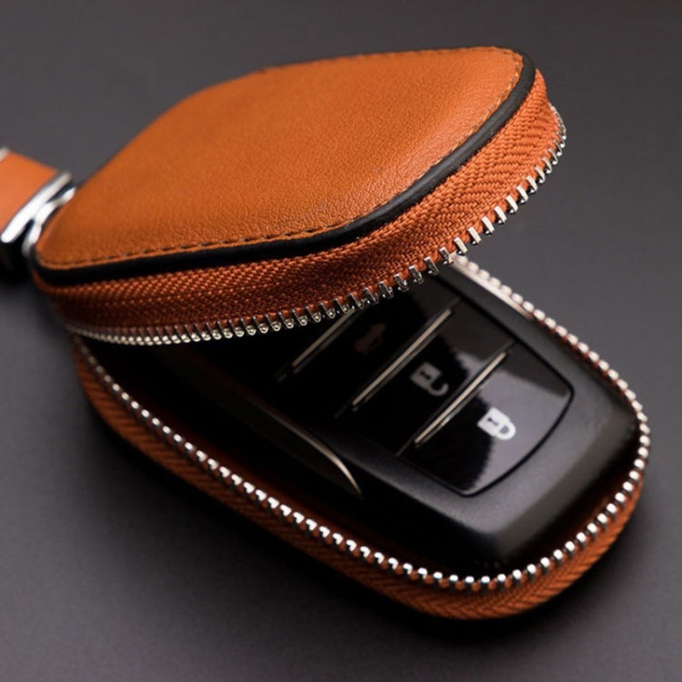 Orange leather key pouch open to reveal key fob slots and zipper trim