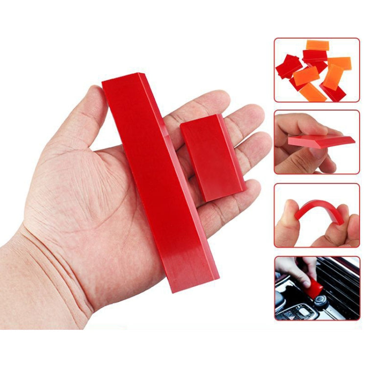 Hand holding two red soft rubber car glass scraper blades