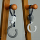 Gray and white U-shaped stroller strap lock hooks with blue securing straps