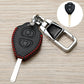 Black Toyota key fob cover with red stitching, metal clip and key blade, angled view