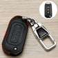 Black leather-style car key cover with red stitching, embossed button icons, metal keyring