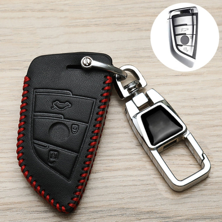 Black leather-style car key cover with red stitching, embossed icon panel, and keyring clip