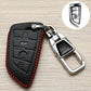 Black key fob cover with red stitched border, embossed icons, and chrome keyring clasp