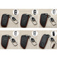 Multiple angles of black key fob covers with red stitching and chrome metal keychain clips
