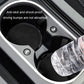 Set of 2 round black suede anti-slip coasters placed in a car cup holder tray.