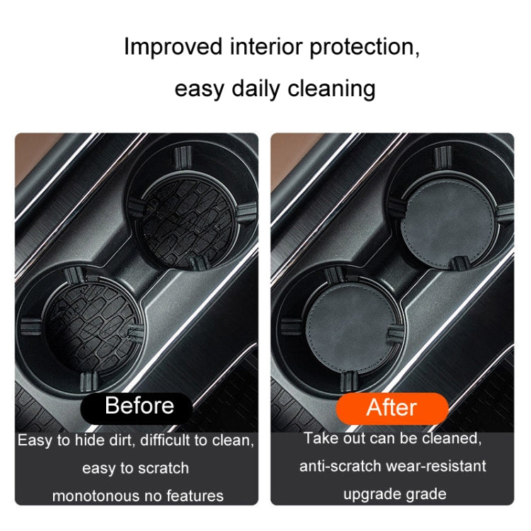 Two gray round suede anti-slip coasters fitted in a car center console cup holder.