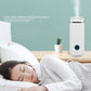 White aroma diffuser humidifier cylinder with blue LED ring, standing on table