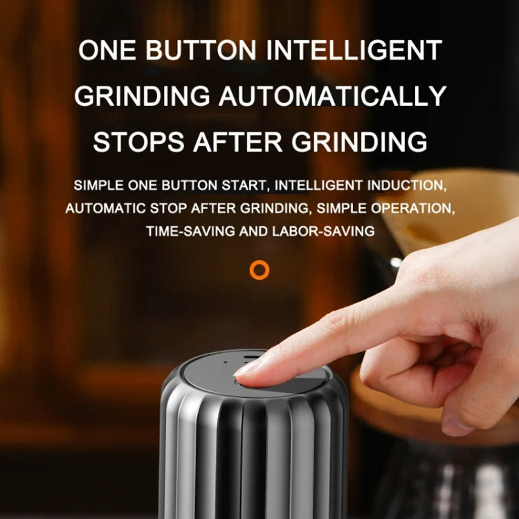 Automatic coffee grinder with finger pressing top button, silver body