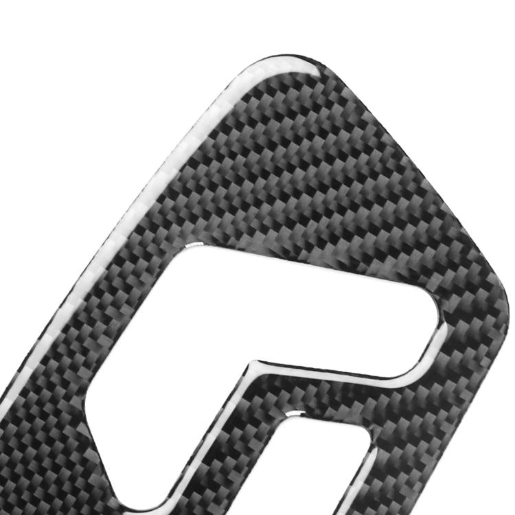 Close-up of carbon-fiber style seat adjustment sticker edge, black weave texture