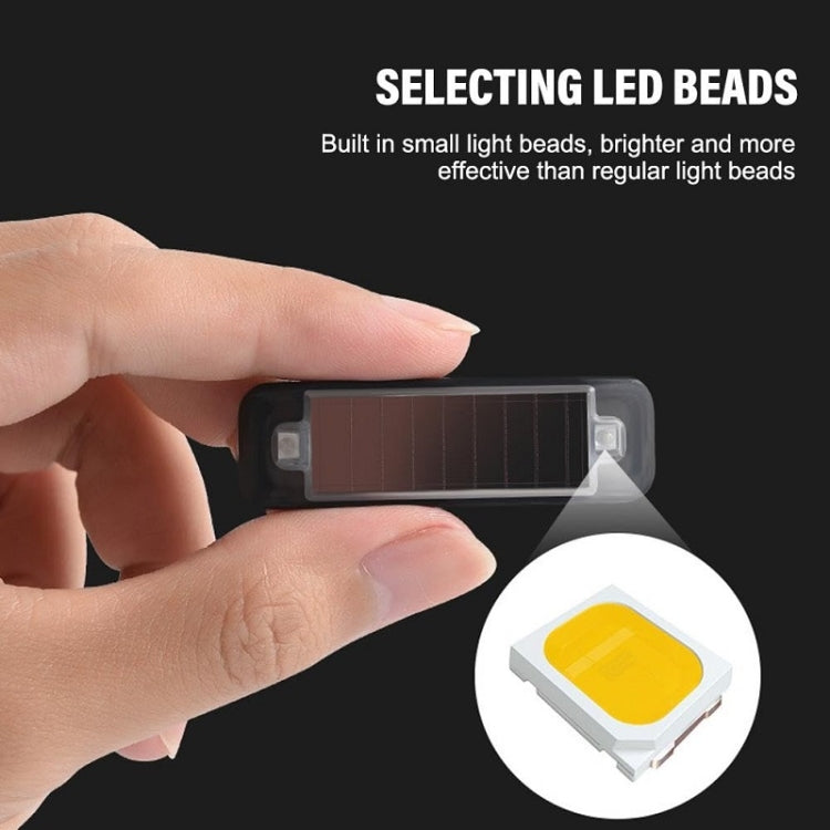 Hand holding mini solar warning light bar, black housing with tinted panel